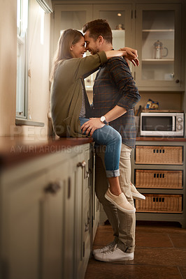 Buy stock photo Love, happy and couple hug in kitchen for bonding, loving relationship and relax together in home. Marriage, morning and man and woman on counter with smile, embrace and affection for commitment