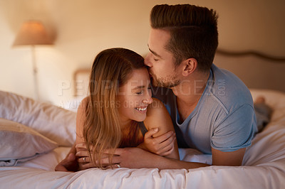Buy stock photo Couple, smile and kiss for support, care and in love for relationship and dating on weekend indoor. Man, woman and happy on bed for bond, playful and romantic for vacation and unwind together  
