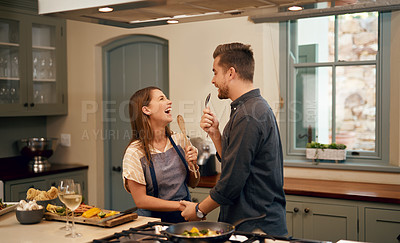 Buy stock photo Love, home and couple in a kitchen, happiness and playful with joy, bonding and loving together. Partners, man and woman with affection, house or singing with humor, relationship or marriage with fun