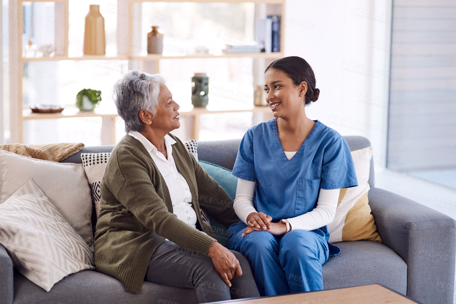 Buy stock photo Healthcare, retirement and a nurse talking to an old woman on a sofa in the living room of a nursing home. Medical, trust and care with a female medicine professional chatting to a senior resident