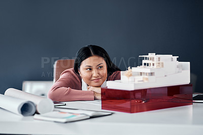 Buy stock photo Woman, architect and thinking by model house in office with ideas, progress and inspiration for solution. Person, engineer and property developer with building, design and smile at agency in Jakarta