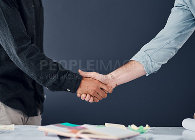 Buy stock photo Shot of two unrecognizable businessman shaking hands in a modern office