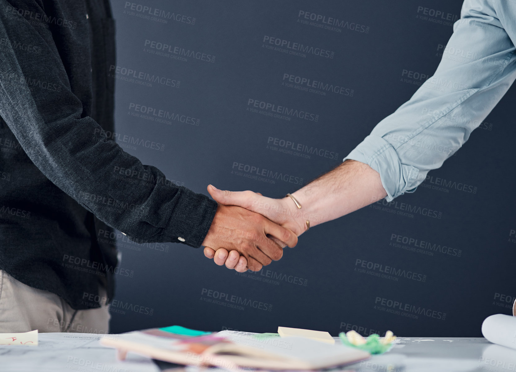 Buy stock photo Shot of two unrecognizable businessman shaking hands in a modern office