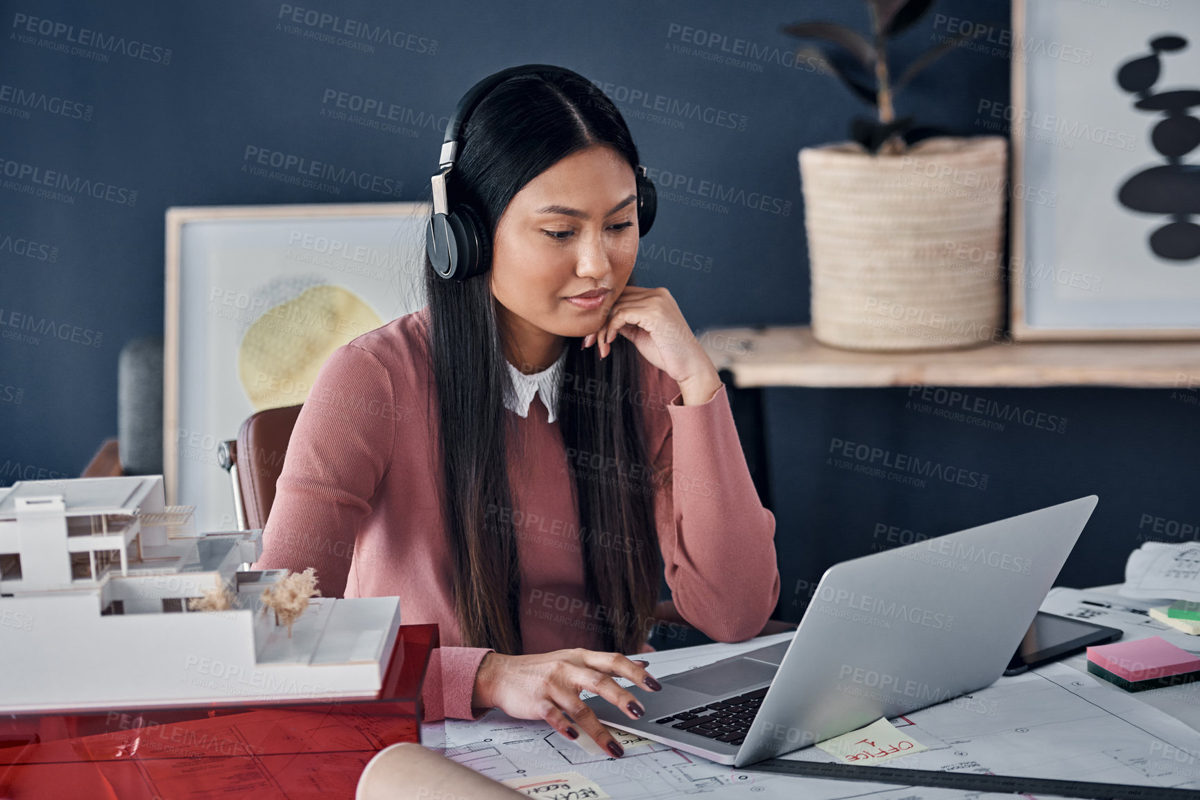 Buy stock photo Architect, woman and headphones with laptop in workplace for construction, thinking and music for inspiration. Person, property developer and audio streaming with idea, vision and review in Jakarta