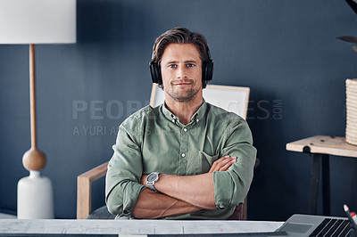 Buy stock photo Portrait of a handsome young businessman wearing headphones while working in his office