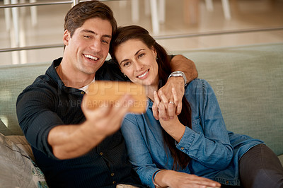Buy stock photo Cropped shot of a couple taking a selfie while relaxing at home