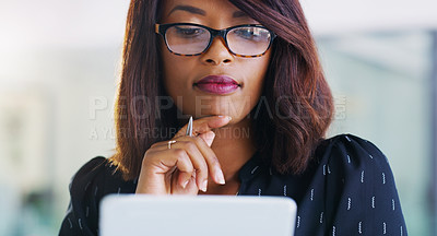 Buy stock photo Shot of an attractive young businesswoman using a digital tablet in her office at work