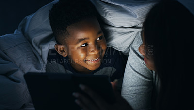 Buy stock photo Shot of a mother reading a bedtime story to her son using a digital tablet at home