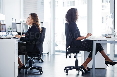 Buy stock photo Shot of a group of young businesswomen using their computers in a modern office