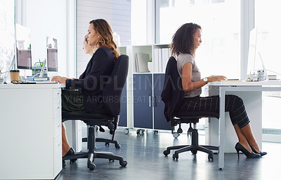 Buy stock photo Shot of a group of young businesswomen using their computers in a modern office