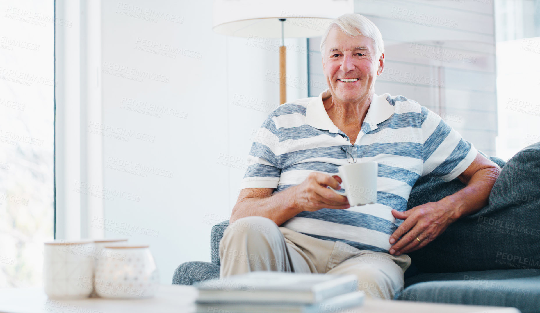 Buy stock photo Shot of a senior man relaxing with a cup of coffee on the sofa at home