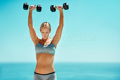 Buy stock photo Blue sky, fitness and woman with dumbbell outdoors for bodybuilding, exercise and strength training. Sports, equipment and power with confidence in nature for weightlifting, workout and muscle growth