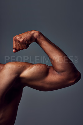 Buy stock photo Studio shot of an unrecognizable muscular sportsman flexing his bicep against a grey background