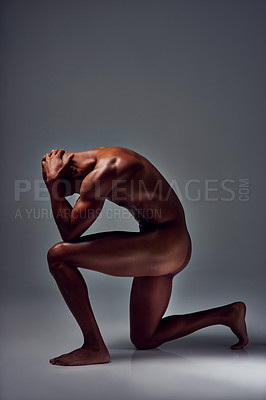 Buy stock photo Studio shot of a muscular young man posing nude on one knee against a grey background