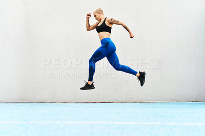 Buy stock photo Full length shot of an attractive young female athlete running along the track