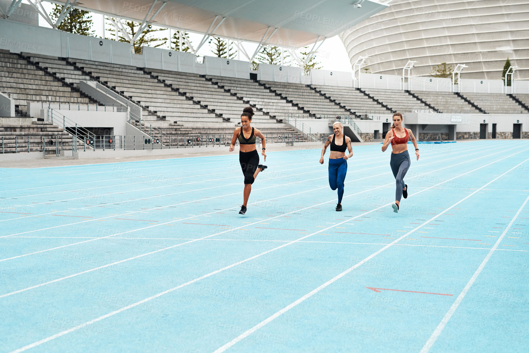 Buy stock photo Women, running and stadium for workout or sport on track, training or exercise for wellness. Group, people and arena with runner for freedom or health in sunshine, commitment and strong with cardio