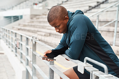 Buy stock photo Stadium, athlete and black man with phone on social media, online chat or news on fitness on break. Typing, communication and runner in arena with smartphone for mobile app or internet notification