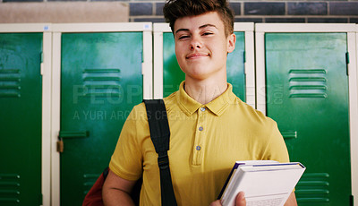 Buy stock photo Cropped shot of a cheerful young school kid holding his books while waiting to go to class inside of a school during the day