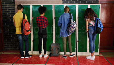 Buy stock photo Rearview shot of a group of school kids attending to their lockers before class inside of a school during the day