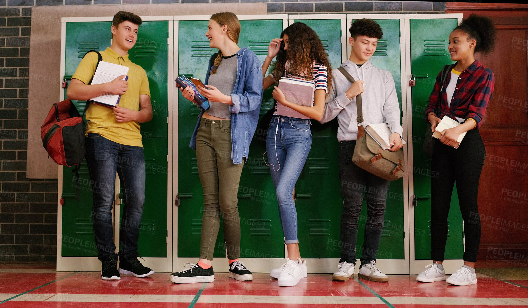 Buy stock photo Cropped shot of a group of cheerful young school kids talking to each other before class inside of a school during the day