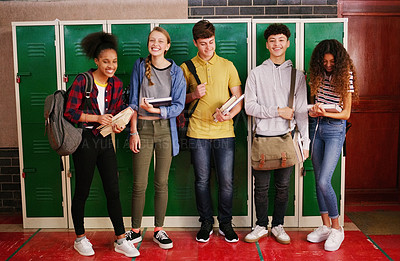 Buy stock photo Portrait of a group of cheerful young school kids talking to each other before class inside of a school during the day
