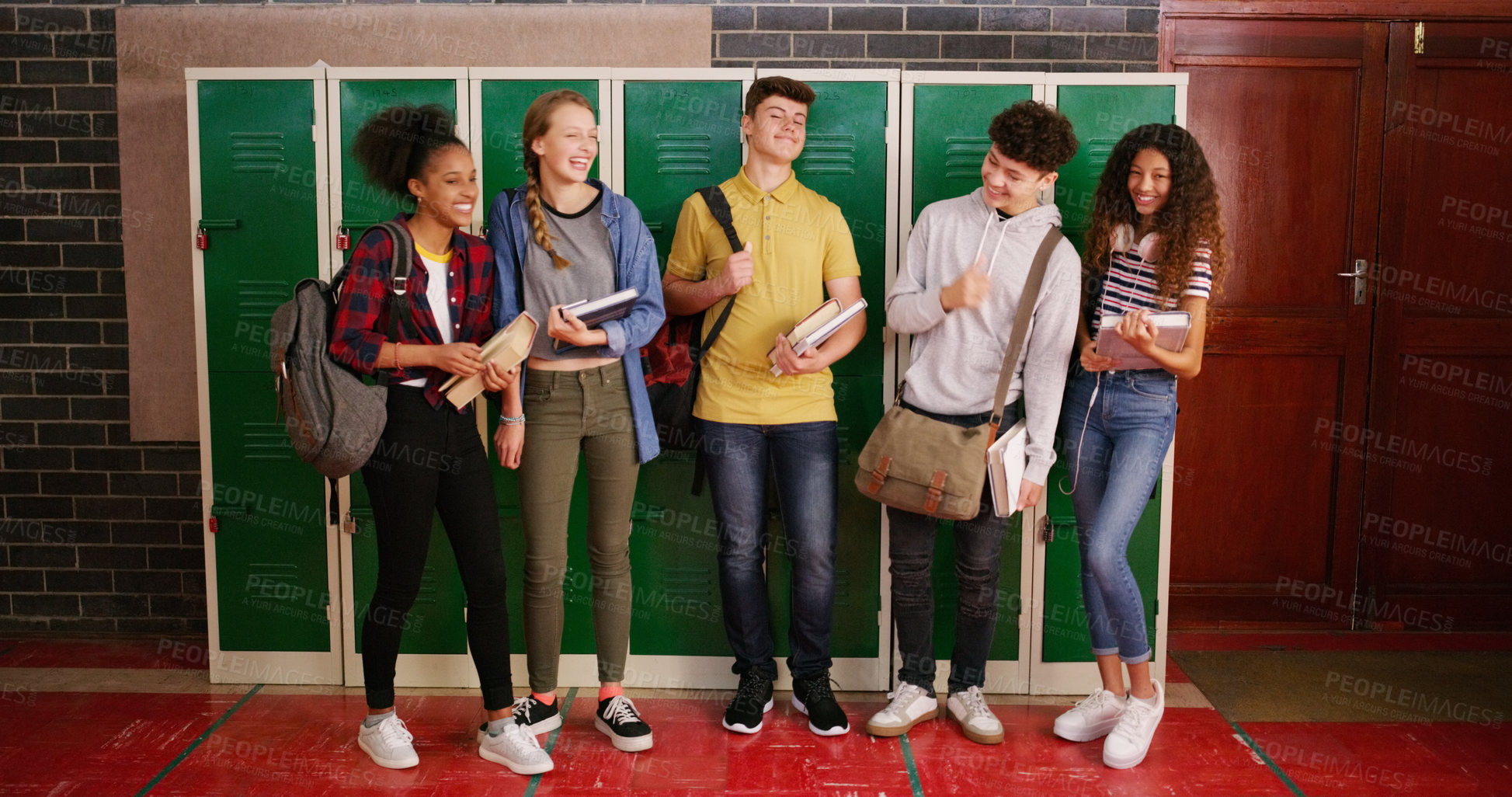 Buy stock photo Cropped shot of a group of cheerful young school kids talking to each other before class inside of a school during the day