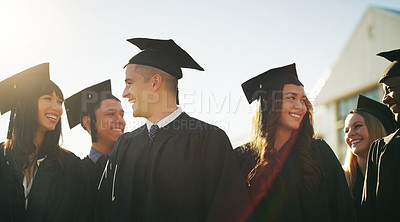 Buy stock photo Cropped shot of a group of cheerful young students standing together on graduation day outside during the day