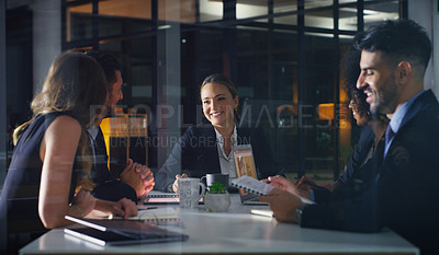 Buy stock photo Cropped shot of a diverse group of businesspeople sitting together and having a meeting in the office late at night