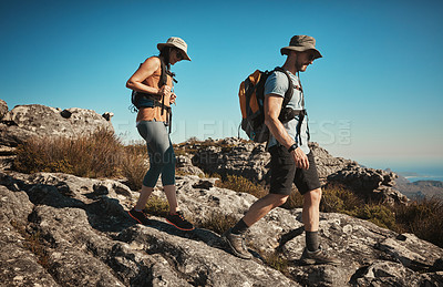 Buy stock photo Hiking, holiday and couple on mountain with backpack for adventure, cliff trekking and fitness. Travel, nature trail and people for wellness and exercise achievement on hill, journey or vacation