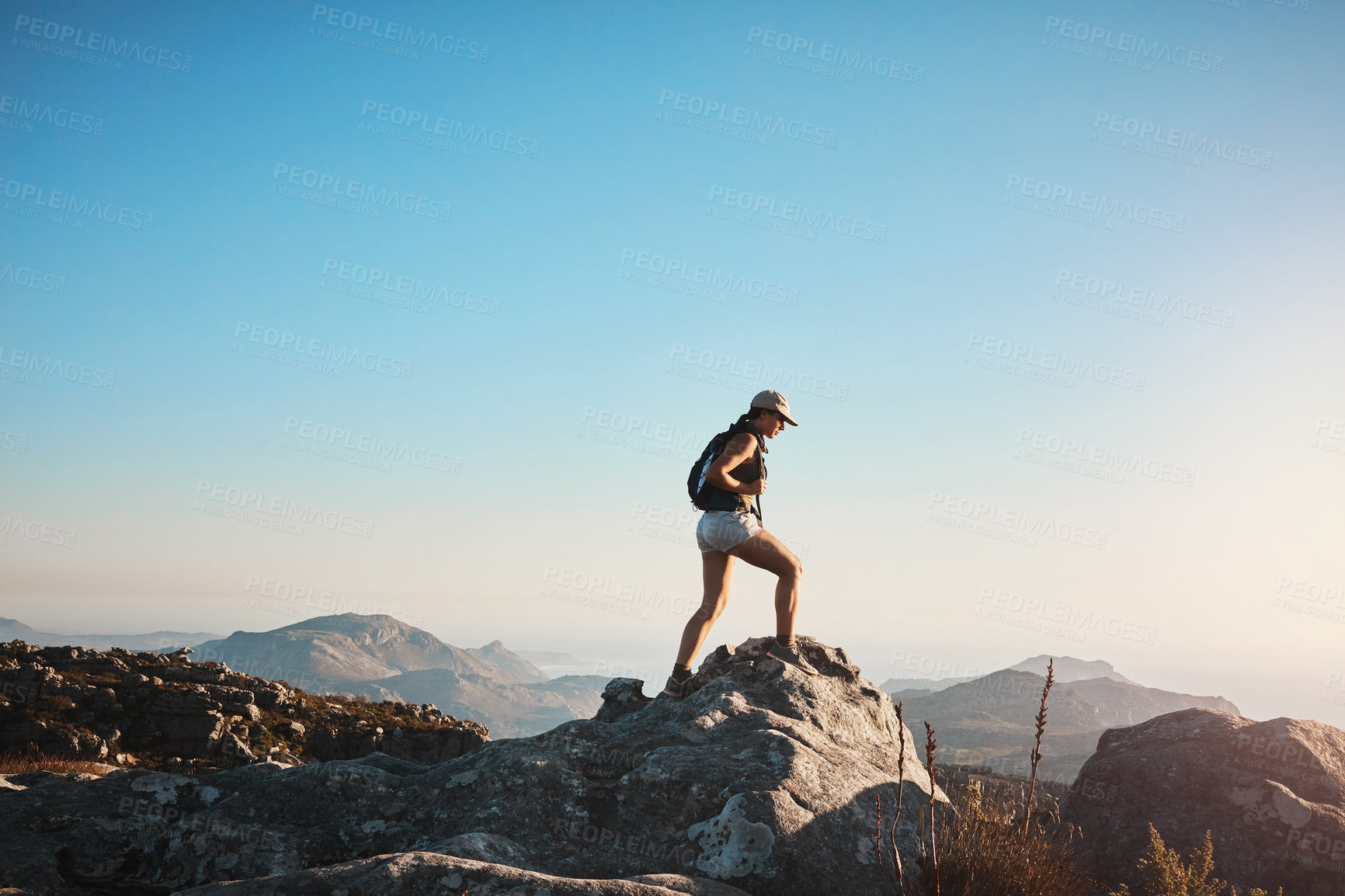 Buy stock photo Shot of a young woman hiking up a mountain