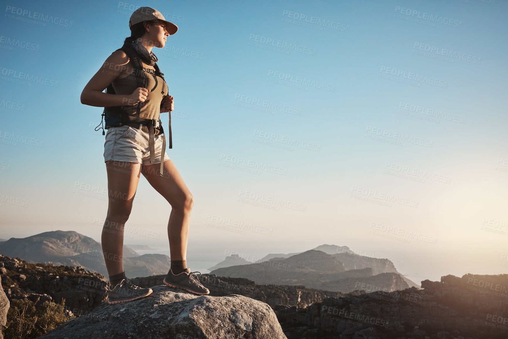 Buy stock photo Shot of a young woman hiking up a mountain