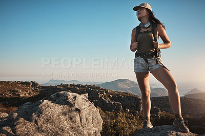 Buy stock photo Shot of a young woman hiking up a mountain