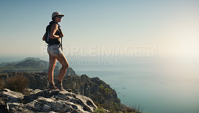 Buy stock photo Shot of a young woman hiking up a mountain