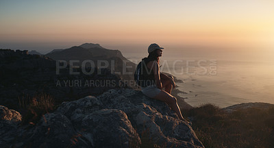 Buy stock photo Shot of a young woman hiking up a mountain at sunset