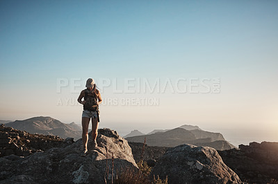 Buy stock photo Shot of a young woman hiking up a mountain