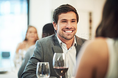 Buy stock photo Cropped shot of an affectionate young man smiling broadly while on a date with his girlfriend in a restaurant