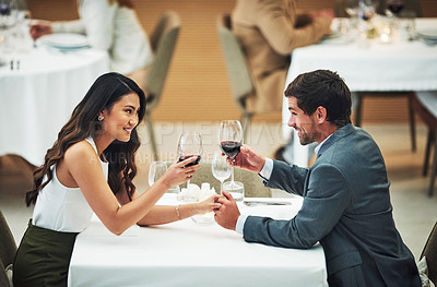 Buy stock photo Love, wine and toast with a couple in a restaurant for their anniversary celebration or romantic dinner. Night, glasses or dates with a young man and woman celebrating an event together with a cheers