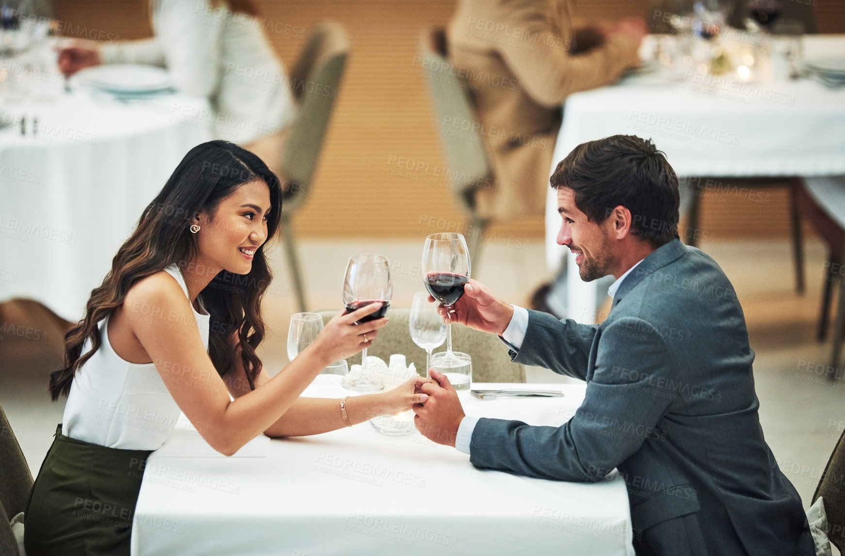 Buy stock photo Love, wine and toast with a couple in a restaurant for their anniversary celebration or romantic dinner. Night, glasses or dates with a young man and woman celebrating an event together with a cheers