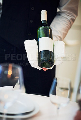 Buy stock photo Waiter, table and server hand with wine and hospitality holding alcohol bottle. Bartender, drink and service of a barman at a fine dining restaurant with staff hands and glasses for drinking