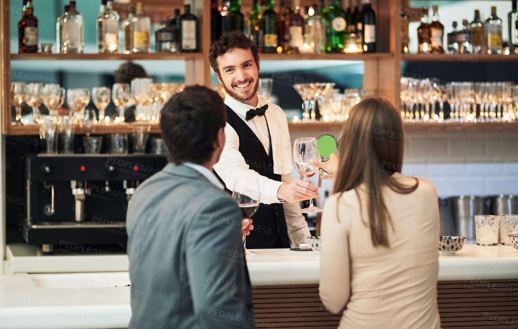 Buy stock photo Bar, barman and serve a couple alcohol drinks on a date with hospitality, happy and smile at a hotel. Waiter, bartender and server help customers or people with good service for a celebration