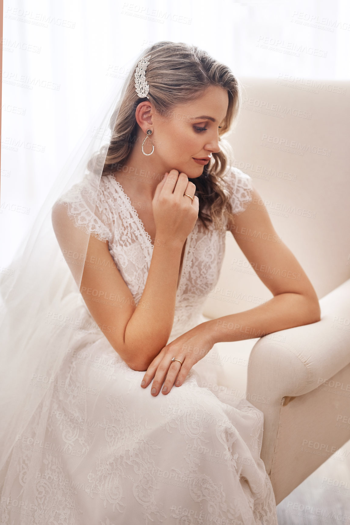 Buy stock photo Cropped shot of an attractive young bride sitting alone in the dressing room and looking contemplative before her wedding