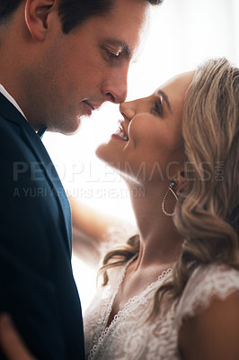 Buy stock photo Cropped shot of a happy young couple standing indoors and looking at each other lovingly after their wedding
