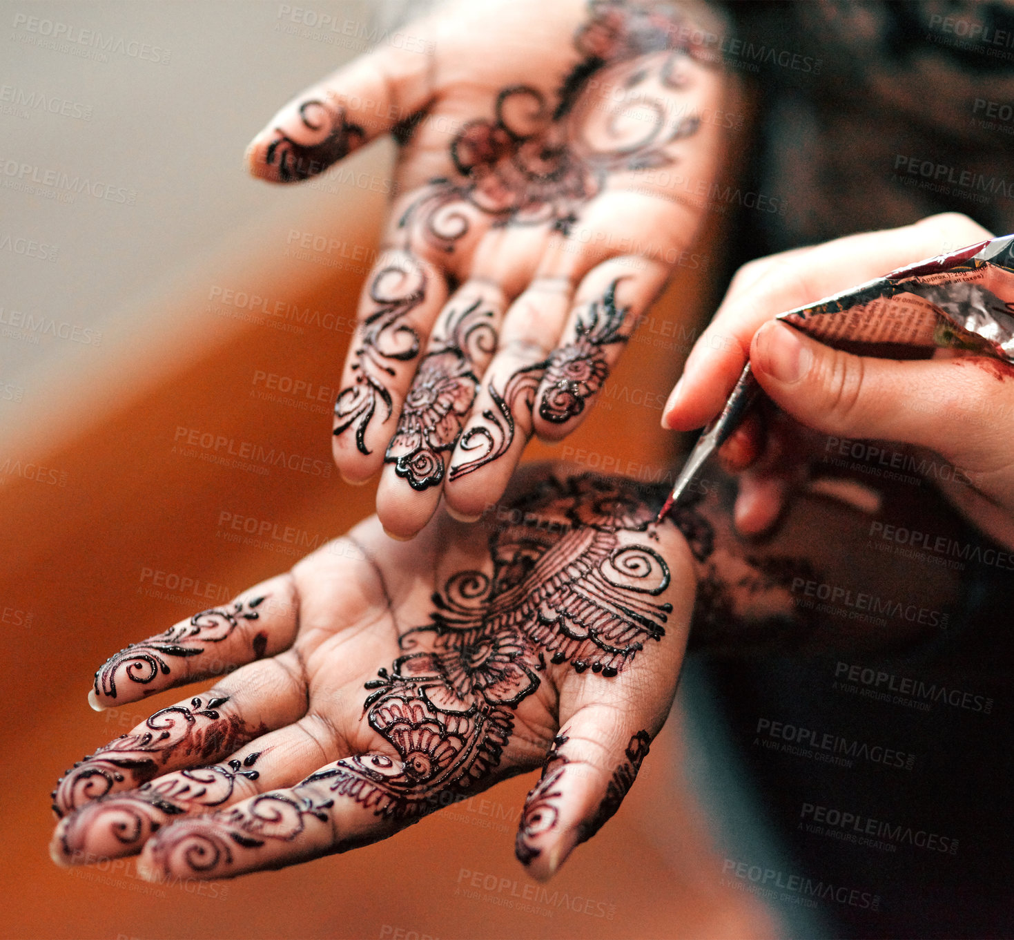 Buy stock photo Cropped shot of an unrecognizable woman getting henna applied to her hands in preparation for her wedding