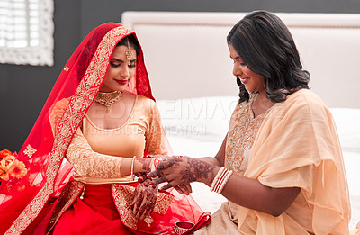 Buy stock photo Indian bride, bridesmaid and bracelets for wedding, celebration and love for marriage. Woman, henna and culture with traditional mehendi, sari and hindu bridal jewelry with support and help dressing