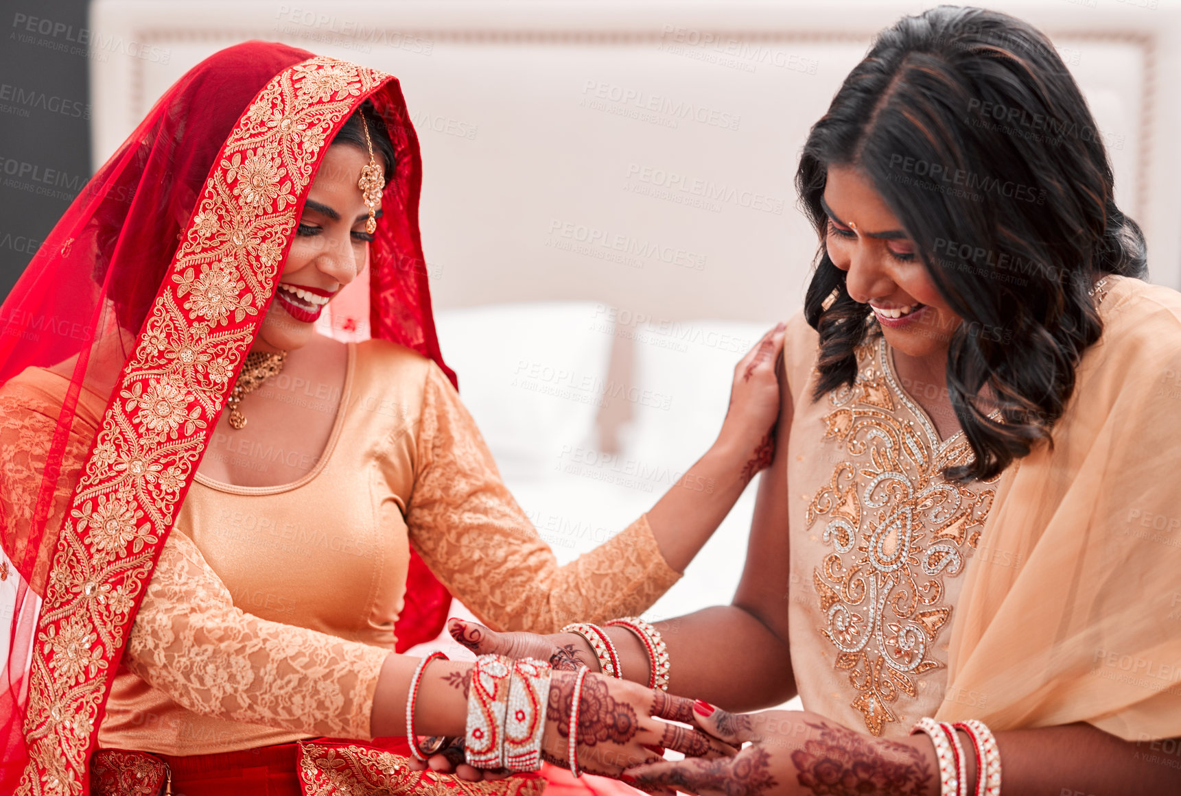 Buy stock photo Shot of a young woman getting her bracelets put on by her bridesmaid on her wedding day