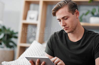 Buy stock photo Man, tablet and thinking for communication, social media or networking in living room. Mobile app, young male person and smile thoughtful on touchscreen for online conversation or website for blog