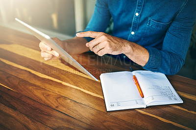 Buy stock photo Cropped shot of an unrecognizable businessman sitting alone in a cafe and using a tablet