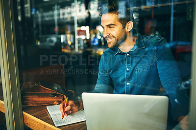 Buy stock photo Cropped shot of a handsome young businessman sitting alone and working in a cafe during the day