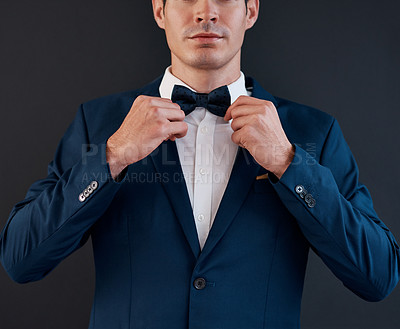 Buy stock photo Cropped shot of an unrecognizable bridegroom adjusting his bowtie in preparation for his wedding