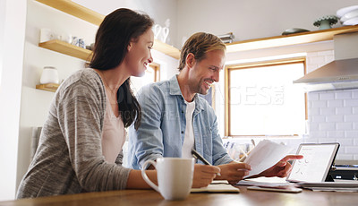 Buy stock photo Cropped shot of an affectionate young couple looking cheerful while going through their budget at home